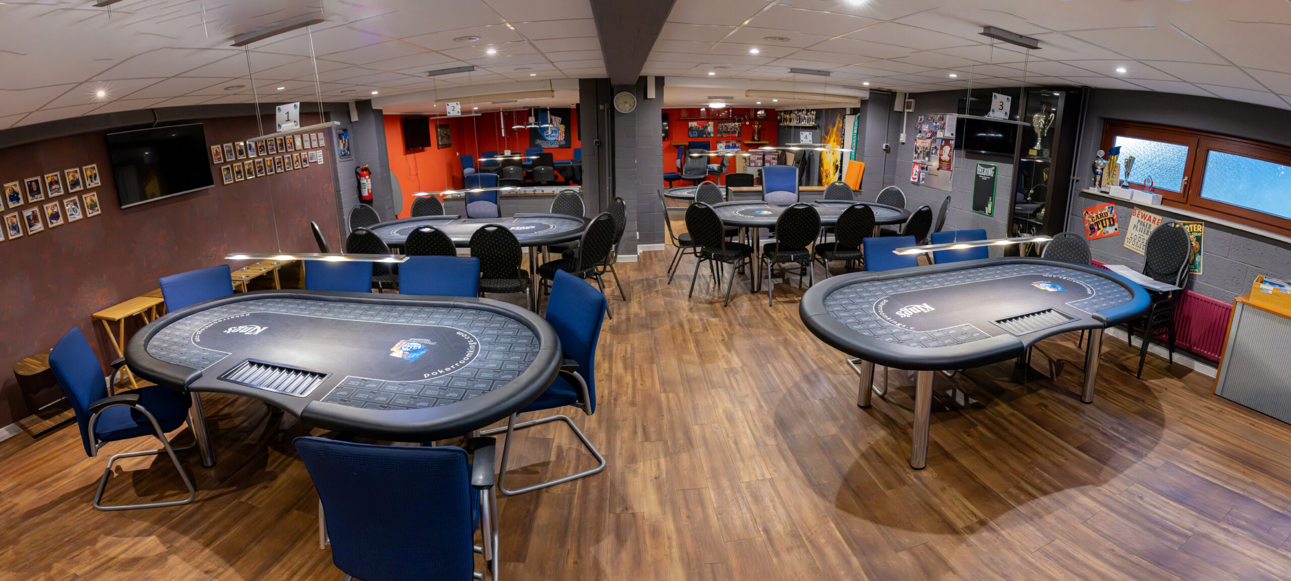 Unser Spielraum im tus BERNE Vereinszentrum: vier Pokertische mit blauen Stühlen, an den Wänden Bildschirme, Turnierfotos und die Pokalvitrine